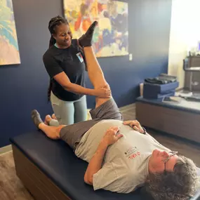 Flexologist Maya provides a one on one assisted stretch session to a member.