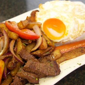 Peruvian style stir-fried  Beef sautéed with onions, tomatoes, Tumi fries, and our mind-blowing signature Lomo Sauce served with a side of  White rice, and topped with a fried egg.