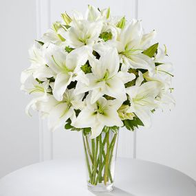 The Spirited Grace™ Lily Bouquet offers sweet serenity with every fragrant bloom. Bright white Oriental lilies create a simple, yet sophisticated bouquet, arranged in a sleek clear glass vase sending your wish for happiness and tranquility.Lilies may arrive in various stages of development. The lily blooms will continue to open, extending arrangement life - and your recipients enjoyment.