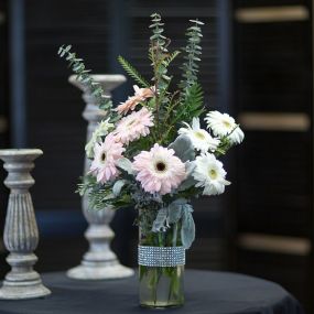 Send this bedazzled arrangement of pink and white gerberas designed in a accented jeweled vase. Available in a array of colors, call us and we can get your desired color