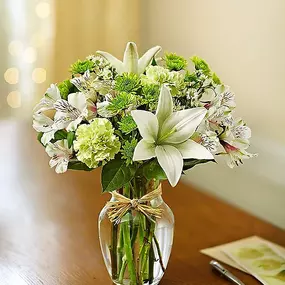 Bring peace and serenity to someone special in your life. Inspired by the quiet beauty of nature, our soothing arrangement is hand-designed with the freshest blooms in delicate shades of green and white and arranged in a classic gathering vase tied with raffia. Just one look will have them smiling and reflecting on your thoughtfulness!