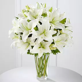 The Spirited Grace™ Lily Bouquet offers sweet serenity with every fragrant bloom. Bright white Oriental lilies create a simple, yet sophisticated bouquet, arranged in a sleek clear glass vase sending your wish for happiness and tranquility.Lilies may arrive in various stages of development. The lily blooms will continue to open, extending arrangement life - and your recipients enjoyment.