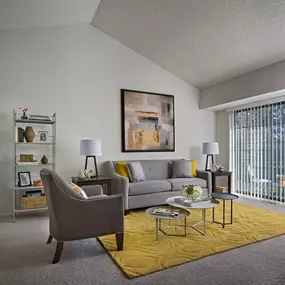 Spacious living room of Plymouth Woods Apartments with a gray and yellow theme