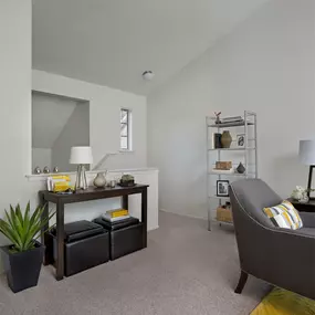 Plymouth Woods Apartments' living room with a gray and yellow theme featuring a table with decors on top
