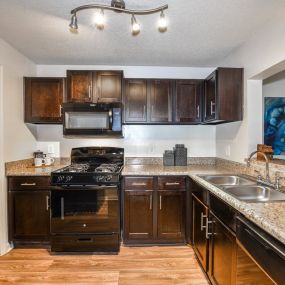 Gourmet Kitchens with Espresso Brown Cabinetry, Brushed Nickel Hardware and Black Applicances at Lakeside at Arbor Place