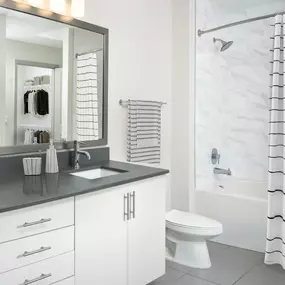 Bathroom with single sink, light cabinets, and bathtub at Camden Music Row apartments in Nashville, TN