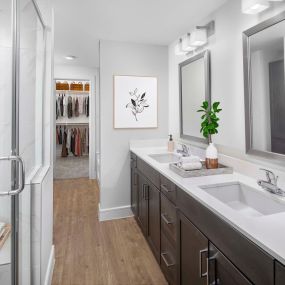 Villas townhome bathroom with walk-in shower, brown cabinets and two sinks at Camden Greenville