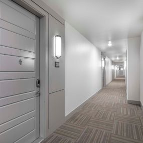 Third floor Villas side hallway with interior-facing front doors at Camden Greenville