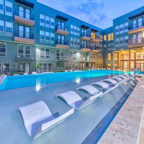 Flats side pool with in-water loungers at twilight