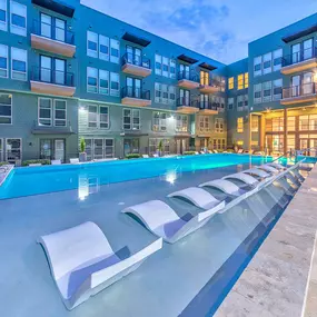 Flats side pool with in-water loungers at twilight