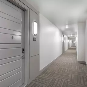 Third floor Villas side hallway with interior-facing front doors at Camden Greenville