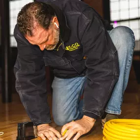 K-CO Electric technician preparing wiring for a floor outlet installation during an interior electrical project.