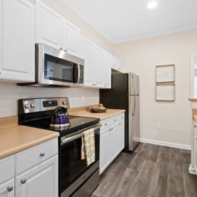 Open Kitchen with Custom Maple Cabinets, Stainless Steel Appliances and Breakfast Bar at Alden Place at South Square Apartments