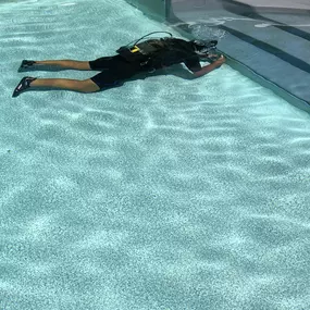 Scuba diver looking for a pool leak.