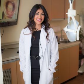 Midtown Dental Care Dr. Randhawa standing by an x-ray