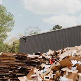 Cardboard accumulates before being baled and shipped to a Greif mill for pulping into new paperboard.