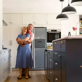 Updated kitchen with a couple admiring the wood refinishing work