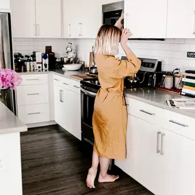 Incredible kitchen with a woman enjoying her new cabinets