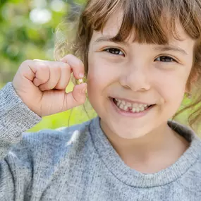 a girl after losing her first tooth