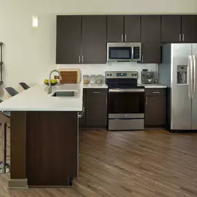 Kitchen with brown cabinetry and stainless steel appliances.