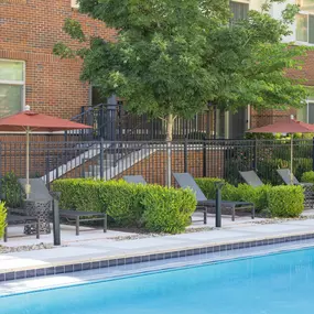 Individual poolside seating areas with umbrellas at Camden Franklin Park apartments in Franklin, TN