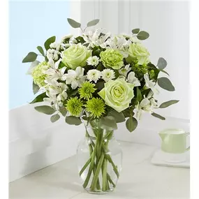 All-around arrangement with green roses, lime green carnations, white Peruvian lilies (alstroemeria), button poms and statice; accented with green hypericum, eucalyptus and assorted greenery.