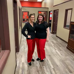 Two girl team members wearing red pants and black tops