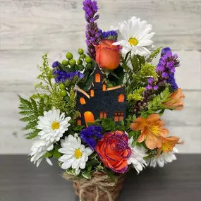 Our colorful Fall flowers surround a light-up Haunted House! What a fun arrangement to add to someone's Fall décor! Spook someone today!