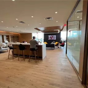 The interior of the new Jeff Wyler Kia of Colerain building, showcased in this photo, features multiple seating areas, a television, and charging ports, adding to the exceptional customer service when waiting to purchase new or used vehicles near Cincinnati, Ohio.