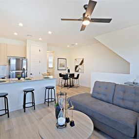 A living room with a couch and a kitchen in the background