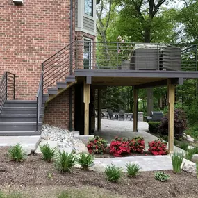Elevated deck with horizontal metal railings and a covered patio area