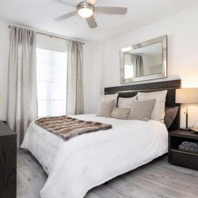 The bedroom with a LED ceiling fan and wood-look flooring at Camden Central apartments in St. Petersburg, Florida.