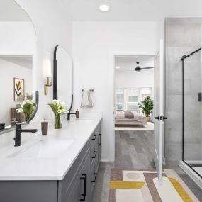 Townhome primary bathroom with double sink vanity and standing shower at Camden Durham apartments in Durham, NC