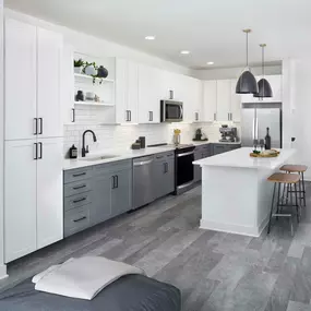 Spacious kitchen with island and stainless steel appliances with wood-style flooring at Camden Durham apartments in Durham, NC.