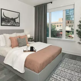 Bedroom with window and wood-look flooring at Camden Durham apartments in Durham, NC