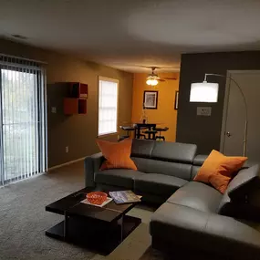 Modern and Stylish Living Room at Abney Lake Apartments with contemporary furnishings, plush carpeting, and large windows.