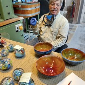 Glass artist Josh Simpson took time out from making new work Friday afternoon to sign some of his colorful bowls for Vermont Artisan Designs. These and other bowls, vases and megaworlds are now waiting for you in Brattleboro.