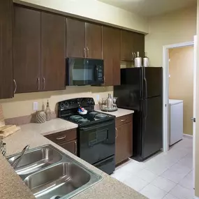 New Kitchens with Ceramic Tile Flooring, Custom Upgraded Cabinetry and Sleek Black Appliances at Courtney Bend Apartment Homes