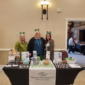 Michigan Eye Institute Employees Standing Behind a Booth