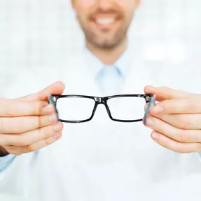 Optometrist handing over a pair of glasses.