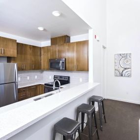 Kitchen and bar seating in a studio  at Park Square Apartments in Bakersfileld
