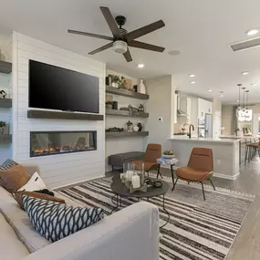 Open concept family room with television above a fireplace in the DRB Homes Recess Pointe community