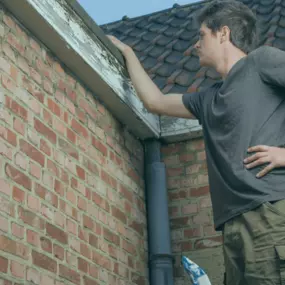 PureDry Restoration technician checking gutters