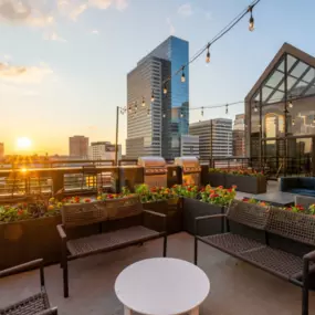 View of the rooftop lounge at sunset with patio furniture and string lights