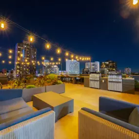 a rooftop lounge with a view of the city at night