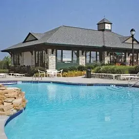 swimming pool with chairs and umbrellas and trees