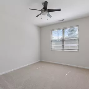Empty living room with a ceiling fan and carpet