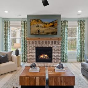 Family room with two white chairs and gray couch in the DRB Homes Saddleridge community