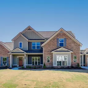 New construction 2-story brick front home with 2-color siding in the DRB Homes Saddleridge community