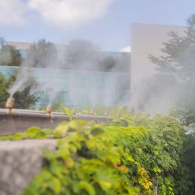 A mosquito misting system on a lawn in front of a business